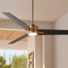 a ceiling fan that is hanging from the ceiling in a room with white walls and windows