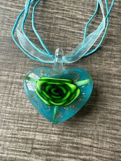 This necklace is made with a glass Lampwork heart and the flower is green, gold accents and a blue background. Note: Colors may vary depending on your monitor  I do have other colors for the necklace strands for both multi and single strand.  If you are looking for a different variation, feel free to touch base with me and I can let you know if I have what you are looking for. Shipping Info: All orders are shipped from Canada and they are sent through Canada Post.  If you would like expedited/fa Green Glass Jewelry Gift, Green Glass Jewelry As Gift, Green Glass Jewelry As A Gift, Blue Glass Heart Beads Jewelry, Blue Glass Jewelry With Heart Beads, Turquoise Flower Necklaces For Gift, Turquoise Glass Jewelry For Gift, Heart-shaped Glass Necklaces For Jewelry Making, Blue Heart Beads Necklace As Gift