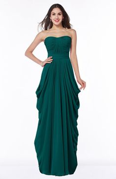 a woman in a strapless green dress poses for the camera with her hands on her hips