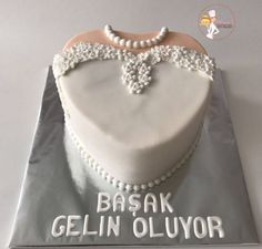 a heart shaped cake on top of a silver plate with the words basak gelin olluyor