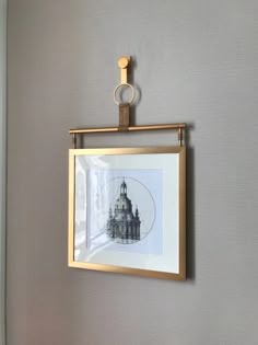 a gold frame hanging on the wall with a black and white drawing in it's center