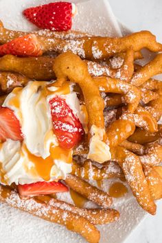 a white plate topped with french fries covered in powdered sugar and strawberries