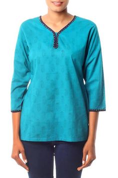 Cool cotton in a rich turquoise tone inspires Isha Jain. She designs this charming tunic with paisley motifs created by hand with the block print technique. Dark blue piping and golden beads complete the charming top. It slips over the head and slits on both sides assure an easy fit. Festive Cotton V-neck Top, Bohemian Festive Cotton Tops, Festive Bohemian Cotton Tops, Blue Fitted Straight Kurta Top, Casual Green Straight Kurta Top, Bohemian Cotton Top With Split Neck, Blue Cotton V-neck Tunic, Green Chikankari Embroidery Straight Kurta, Green Chikankari Embroidered Straight Kurta Top