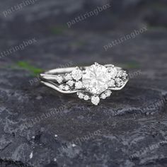 a white gold engagement ring set with round brilliant cut diamonds on top of a rock