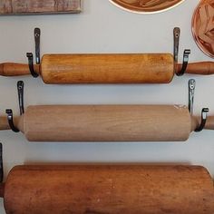 three rolling doughs are hanging on the wall next to other baking supplies and utensils