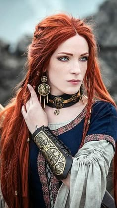 a woman with long red hair and jewelry on her neck is posing for the camera