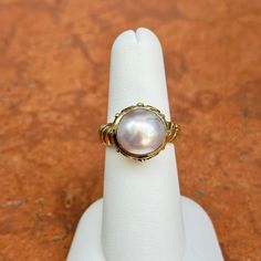 New, but old pieces, never worn, recently acquired from a premier jeweler located in Minneapolis, MN for many years- A rare opportunity! 14KT yellow gold genuine, bezel-set, Mabe pearl ring with Etruscan/ filigree design. Size 6.25 Sizable by us for a fee or your local jeweler Weight: 7.90 grams Band width: 4mm 11mm pearl Stamped 14k Heirloom High Luster Oval Pearl Ring, Classic Wedding Jewelry With Cabochon, Classic Oval Ring With High Luster, Classic Oval Rings With High Luster, Antique Round Jewelry With High Luster, Classic Oval High Luster Ring, High Luster Vintage Ring Jewelry, Antique Round High Luster Jewelry, Antique High Luster Round Jewelry