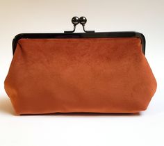 "Velvet rust orange clutch with 100% cotton rust orange lining. Handy pocket inside holds business cards, ID and credit cards. The purse is large enough to hold sunglasses, cell phones, pens, compacts...everything you need for a night out! Choose your metal purse frame finish: antique bronze (pictured), silver, rose gold or gunmetal Dimensions: 8\" wide metal frame on top, 8.75\" wide at the bottom, 3\" deep x 5\" tall Inside pocket measures 2\" x 4\". Add a personalized message of any length to Orange Clutch, Velvet Dog Collar, Orange Handbag, Easter Dog, Metal Purse, Dog Collar Bows, Purse Frame, Dog Collar Bow Tie, Velvet Clutch