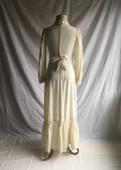 "1970s prairie dress label- Patty O'Neil cream color w/oatmeal specks cotton muslin feel lace trim- synthetic feel long sleeve w/button cuff v neck w/collar tie back from front high waist band zip up back w/hook eye top closure floor to ankle length, more or less depending on wearer's height very good vintage condition, light wear label size 7 (see below) fits like a modern small, please go by measurements measures, lying lat, shoulder-13 3/4\" chest-17\" waist-13\" (26\" waist total) hip-21\" s Cream Long Sleeve Vintage Dress For Summer, Cotton Maxi Dress With Lace Trim For Daywear, Cotton Prairie Dress For Daywear, Fall Cream Dress With Lace Trim, Cream Lace Trim Dress For Fall, Fitted Long Sleeve Cotton Prairie Dress, Fitted Cotton Prairie Dress For Daywear, Cotton Long Sleeve Prairie Dress, Fitted Cotton Cream Dress