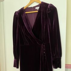 Nwot Aubergine Colored Dress Approx. 37" Long From Center Back Neck To Hem. Length Is Based On Size 6 And Varies 1/4" Between Sizes Tailored Fit Through The Chest, Waist, And Hips; Sits Close To The Body Velvet Fabric: Smooth And Soft; Stretchy And Supportive Surplice V-Neck; Sheath Silhouette Hidden Zipper At Center Back Shirred-Shoulder Long Sleeves Covered Buttons At Side Front Of Overlapping Skirt And At Cuffs Lined Polyester/Spandex; Lining: Polyester Dry Clean Elegant Purple Dress With Button Closure, Formal Purple Dress With Buttons, Aubergine Color, Surplice Dress, Velvet Dresses, Nike Tennis Dress, Large Sweaters, Velvet Trim, Dresses For Wedding