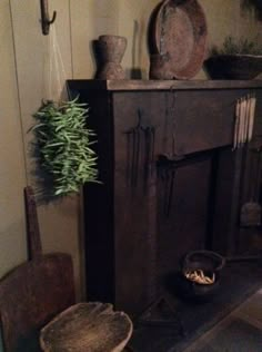 an old fashioned fireplace in a room next to two chairs and a potted plant