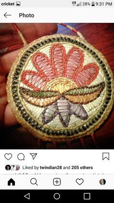 someone is holding up a small hand embroidered ornament