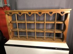 a wooden shelf sitting on top of a refrigerator