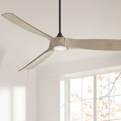 a ceiling fan that is hanging from the ceiling in an empty room with white walls and windows