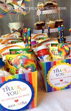 there are many cupcakes and candy in the boxes on the table with thank you tags