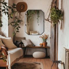 a living room with a couch, mirror and potted plants on the table in front of it