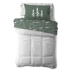 a green and white comforter with trees on it