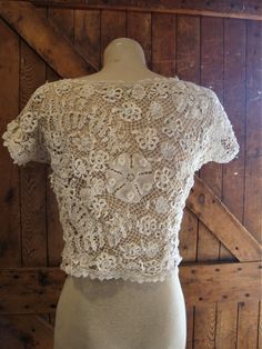 "This is an antique Irish lace blouse, from around 1910-20. The flowers are outstanding, so dimensional and different. There are no closures, goes over your head. The hem is accented with filet lace. There are a few broken threads here and there. I did not launder or press this blouse, just presenting it as found. Comes from a smoke free home. Measurements: Bust: 38\" Waist: 34\" Hip: 42\" Across Shoulder: 15.5\" Back Length: 16.5\" Please ask me any questions you may have before buying as this Vintage Fitted White Lace Top, Vintage White Fitted Lace Top, Short Sleeve Lace Top With Lace Trim For Wedding, Short Sleeve Lace Top For Wedding, Wedding Lace Top With Short Sleeves, Vintage Cream Lace Top, Vintage Lace Top With Lace Collar, Vintage Delicate Lace Top, Vintage Fitted Wedding Tops