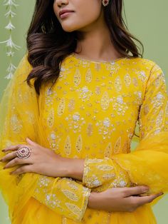 A three-piece sunshine embroidered sharara set from the Redpine Designs collection. This gorgeous sunshine yellow printed flared sharara pant is paired with a floral embroidered kurta. The yellow color with moti, cutdana, sequins work enhances the graceful georgette sharara set. The yellow sharara has beautiful digital floral print with heavy flare style. The embroidered kurta has a jewel neckline with digital floral print all over. This beautiful sharara set includes a yellow net dupatta with e Designer Yellow Chikankari Embroidery Palazzo Set, Designer Yellow Palazzo Set With Chikankari Embroidery, Yellow Anarkali Palazzo Set With Straight Kurta, Yellow Chikankari Embroidered Palazzo Set, Yellow Palazzo Set With Gota Work And Straight Kurta, Festive Yellow Chikankari Palazzo Set, Traditional Yellow Palazzo Set With Gota Work, Yellow Palazzo Set With Straight Kurta And Gota Work, Yellow Chikankari Embroidery Palazzo Set For Eid