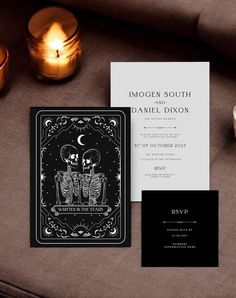 the wedding stationery is laid out on a table next to candles and some cards