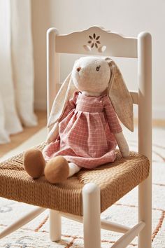 a stuffed rabbit sitting on top of a wooden chair