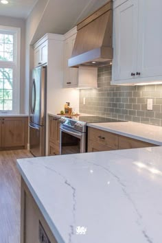 a kitchen with marble counter tops and white cabinets