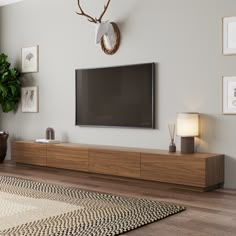 a large flat screen tv mounted to the side of a wooden cabinet in a living room