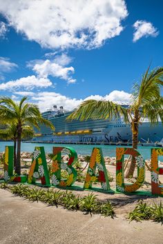 there is a large cruise ship in the background and some palm trees on the beach