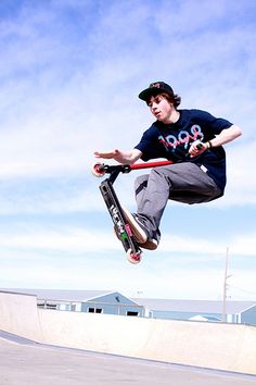 a man flying through the air while riding a scooter in a skate park