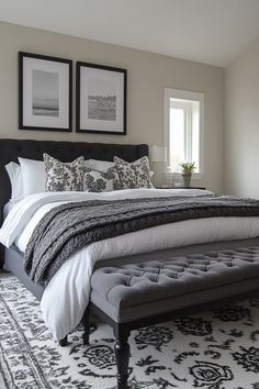 a large bed sitting in a bedroom next to two framed pictures