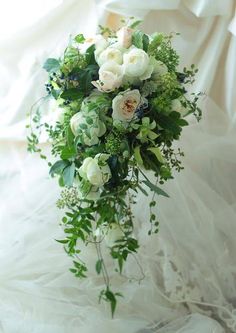 a bridal bouquet with white flowers and greenery