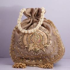 Beautiful Hand Embroidered Zardosi Work Golden Sequin Handbag Polti For Wedding Partys Giveaway Bridal Bag Shimmering Bag Dress Matching Bag Key Features: Embroidery art work This potli is good match with both Indian and western outfits and are superb for wedding and festive parties This would be best complement to your designer saree, lenhga or any other kind of dress This is the combination of traditional and modern embroidery work This is enough to keep your accessories and all needed essenti Beige Embroidered Fabric For Reception, Embellished Pouch Bag For Reception, Bollywood Style Embroidered Evening Potli Bag, Bollywood Style Handwork Bags For Reception, Bollywood Style Potli Bag For Reception, Bollywood Style Bags With Handwork For Reception, Embroidered Pouch For Reception, Festive Bag With Pearl Embroidery For Reception, Festive Embroidered Clutch Evening Bag