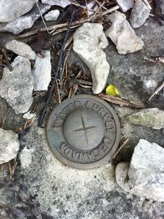 there is a stone with a clock on it in the ground next to some rocks