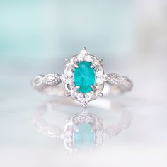 Gorgeous Vintage Inspired Neon Paraiba Tourmaline Ring Made of Solid Sterling Silver, Rhodium Plated (S925) Accented with Simulated Diamonds Center Stone: Paraiba Tourmaline Gemstone Creation: Lab-Created Stone Cut: Oval Color: Turquoise Gem size: 6.0 x 4.0 mm Carat Weight: 0.43 (approx.) Gemstone Origin: Brazil Can be made in solid gold and customized to a different gemstone. Please contact us if you have special requests. Handling time: 1-2 business days Free domestic shipping. Usually takes 2 Elegant Silver Turquoise Ring With Birthstone, Elegant Silver Turquoise Birthstone Ring, Turquoise Birthstone Ring With Accent Stones For Anniversary, Classic Emerald Ring With Gemstone Accents For Wedding, Turquoise Emerald Ring For Anniversary, Turquoise Oval Emerald Ring For Anniversary, Oval Turquoise Emerald Ring For Anniversary, Elegant Turquoise Ring With Accent Stones, Emerald Birthstone Ring With Gemstone Accents For Wedding