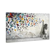 a person standing in front of a wall with many colorful birds flying over it,