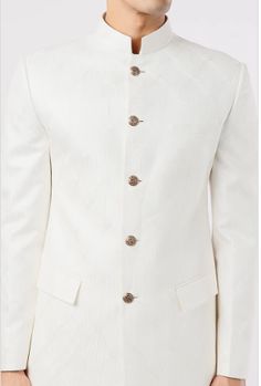 Featuring an ivory bandhgala jacket in slub silk base with metal buttons. It is paired with matching pants. Traditional White Semi-formal Suit, Elegant Cream Sherwani For Semi-formal Occasions, White Classic Sherwani For Semi-formal Occasions, Formal Off White Bandhgala For Festive Occasions, Semi-formal White Sets With Buttons, White Semi-formal Sets With Buttons, White Classic Semi-formal Sherwani, White Buttoned Semi-formal Sets, Classic White Semi-formal Sherwani