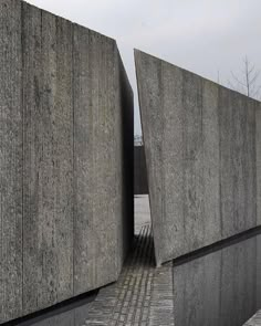 two large concrete structures sitting next to each other on top of a stone floored area