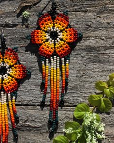 These beaded flower earrings are brought to you by the courtesy of the Huichol Tribe of Tepic, Mexico. We are blessed to be able to partner with them. Every purchased pair of earrings helps to support this tribe. * 100% handmade by a person who puts all their effort and dedication so that you have a product of the highest quality -Enjoy the details of this gorgeous set...including stainless steel hooks and bright yellow, orange, and white beads. -We are proud to share with you a little glimpse of the Huichol culture. They are amazing artists with exceptional skills. -These pairs of earrings are an artistic piece made with the highest quality for you to enjoy. -Through your purchase you are supporting artisans who make from this art their way of living -For more information about our partne Bohemian Orange Flower Beaded Necklace, Bohemian Orange Flower Earrings For Gift, Orange Bohemian Flower Earrings For Gift, Bohemian Orange Flower Beaded Earrings, Bohemian Orange Flower Jewelry, Orange Bohemian Flower-shaped Jewelry, Bohemian Orange Flower-shaped Jewelry, Bohemian Flower Beads For Beach, Artisan Beaded Earrings For Festivals