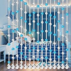 blue and white beaded curtains hanging from the ceiling in a room with wooden floors