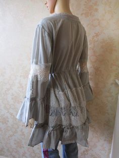 "Vintage Italian cotton and lace dress\\top with a drawstring waist.  It is a beige\\grey cotton with white lace inserts at the front, around the skirt and the sleeves.  Them hem is tiered an the sleeves flare at the elbow.  There are Four tiny metal buttons to close the neck. Godd condition and very pretty. Bust flat, pit to pit;  20\" Waist flat;  17 1\\2\" Length from back of neck;  32\" Inside sleeve;  15\" Front opening;  6\" Made by ELISA CAVALETTI cotton  lace" Spring Cotton Lace Patchwork Dress, Spring Cotton Lace Dress With Lace Patchwork, Bohemian Summer Dress With Lace Collar, Spring Cotton Lace Dress With Lace Trim, Bohemian Spring Lace Dress With Ruffles, Bohemian Lace Dress With Ruffles For Spring, Bohemian Lace Trim Dress For Spring, Bohemian Lace Dress With Lace Trim For Spring, Beige Cotton Dress With Lace Trim