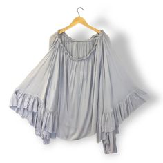 Free People Here To Stay Tunic Top Size Medium Gray Lightweight Gauzy Tunic In An Oversized Silhouette. Semi-Sheer Elastic Neckline With A Tie Tassel Detail Off-The-Shoulder Style Dramatic Statement Sleeves With Ruffle Trim Unfinished Edges Endless Summer- Whether You Live The Beach Lifestyle Year-Round Or Dream Of Making The Great Escape, The Endless Summer Collection Is Full Of Our Most Effortlessly Ethereal Styles Under The Sun. Hand Wash Cold Import Approximate Measurements For Size Small Le Gray Blouse, The Endless Summer, Statement Sleeves, Grey Blouse, Cape Sleeves, Beach Lifestyle, Refashion Clothes, Oversized Silhouette, Inception