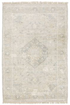 an antique rug with fringes on the edges and a medallion design in grey, beige and white