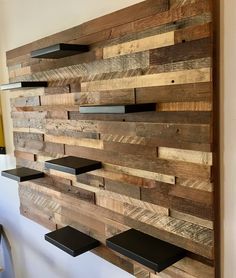 a wooden wall with shelves on it and some black metal brackets hanging from the side