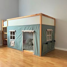 a child's play house in the corner of a room with hardwood floors and walls