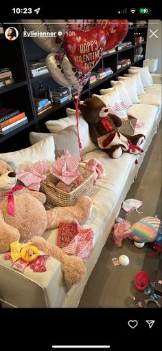 teddy bears and balloons on a couch in a living room