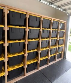 several bins are lined up against the wall in a storage area with yellow and black containers