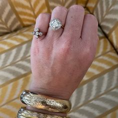 a woman's hand with three different rings on it