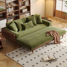 a green couch sitting on top of a wooden floor next to a bookshelf