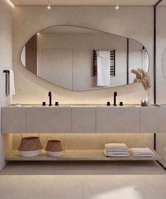 a bathroom with a large mirror above the sink and two vases on the counter