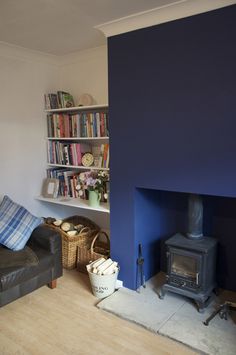 a living room with a couch, book shelf and fire place in front of it